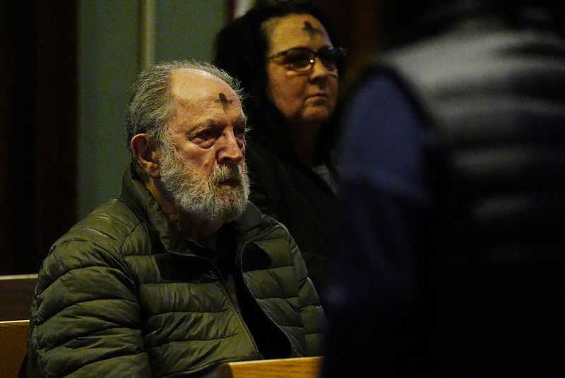 Gary Thomann and Patti Yokopovich, both of Webster, pray after distribution of ashes at Holy Trinity Church in Webster on March 5, 2025.
