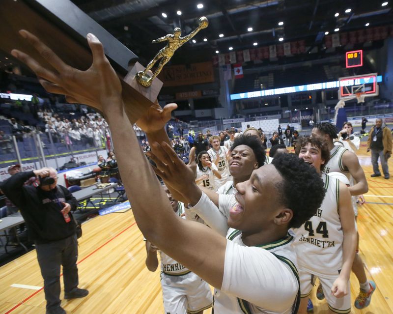 Rush-Henrietta celebrates with the championship brick after their 53-50 win over Fairport during their Section V Class AAA final Saturday, March 8, 2025 at the Blue Cross Arena.
