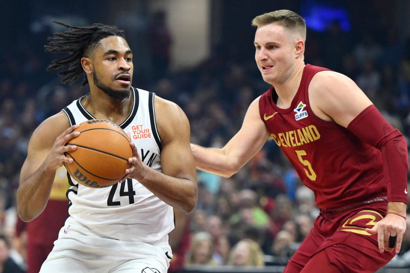 Mar 11, 2025; Cleveland, Ohio, USA; Brooklyn Nets guard Cam Thomas (24) dribbles beside Cleveland Cavaliers guard Sam Merrill (5) in the first quarter at Rocket Arena. Mandatory Credit: David Richard-Imagn Images