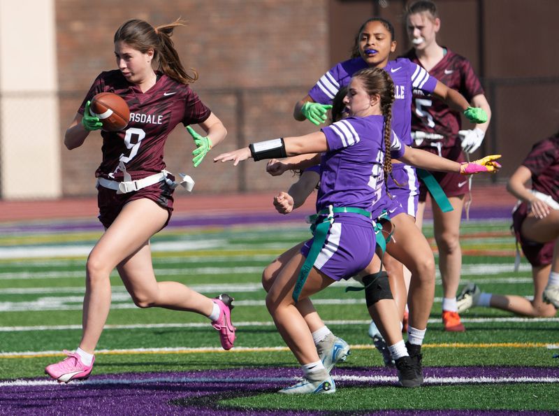 Scarsdale’s Leah Brown (9) looks fro some running room in the New Rochelle defense during flag football action at New Rochelle High School April 23, 2025. Scarsdale won the game 14-7.