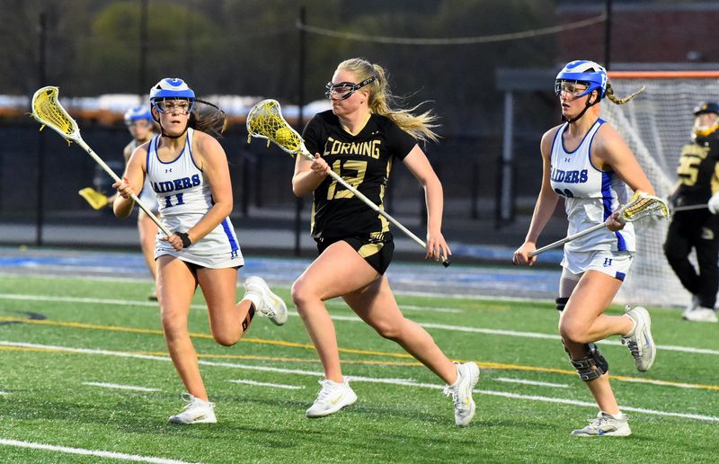 Corning's Gracee Work (13) controls the ball as Horseheads' CarLynn Sindlinger (11) and Anna Lowe (26) defend during the Blue Raiders' 12-11 win in girls lacrosse April 24, 2025 at Horseheads High School's stadium.