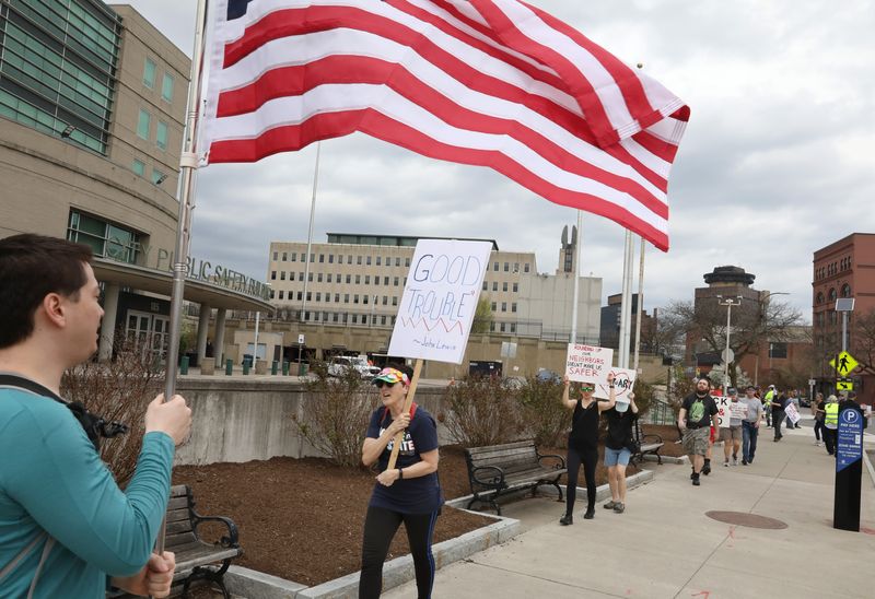 Protesters march in front of the Public Safety Building in Rochester Tuesday, April 29, 2025. The protest, organized by 50501 Rochester, was in response to the visit to Rochester by the Trump administrations ‘border czar’ Tom Homan.