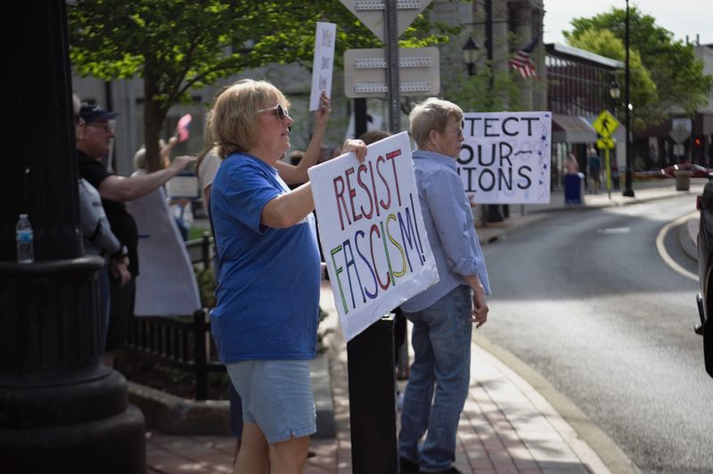 About a dozen people gathered on Court Street in downtown Binghamton on May 1, 2025 to protest the Trump administration and its policies.