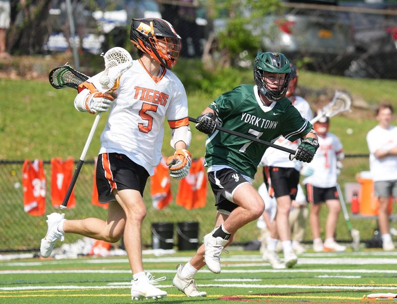 Mamaroneck's Carsen Winters (5) works against Yorktown's Chase Reynolds (7) during their 14-5 win in lacrosse action at Mamaroneck High School on Saturday, May 3, 2025.