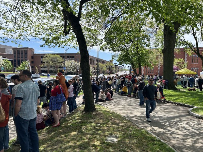 Hundreds of people gather around the perimeter of Washington Square Park to watch the dachshunds march in the parade.