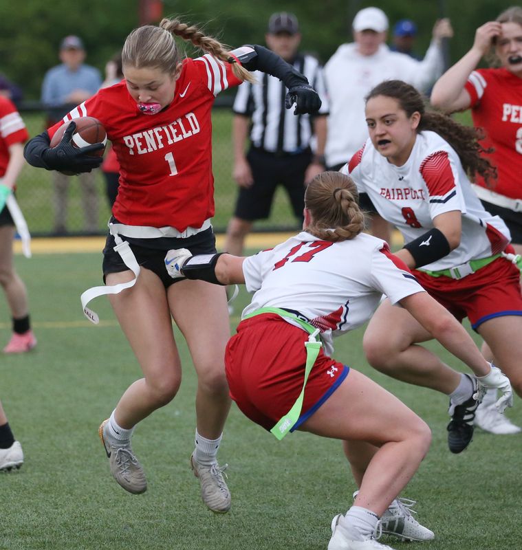 Penfield quarterback Sophia Puccia spins out of a flag pull attempt by Fairport’s Anna Ralston to pick up yards on a quarterback keeper during their Section V Class A flag football sectional final at Monroe Community College in Rochester Tuesday, May 27, 2025.