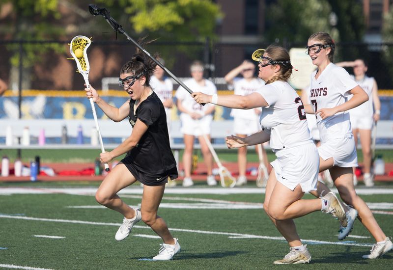 Rush-Henrietta's Isabella Artessa runs with the ball while Penfield's Olivia Reed defends during the Section V Class A championship Wednesday, June 4 at the University of Rochester.