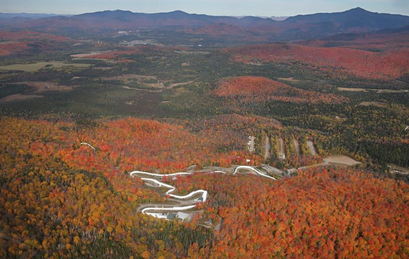 The twists and turns of the Mount Van Hoevenberg Olympic Bobsled Run are surrounded by the exploding colors of fall deep in the Adirondacks near Lake Placid. The photo was taken on a foliage flight over the High Peaks by Adirondack Flying Services in Lake Placid.