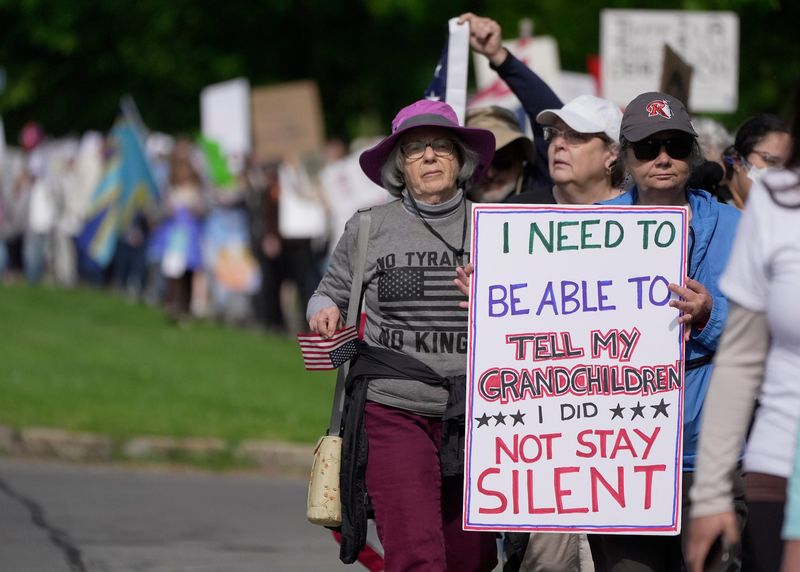 Margy Peet and Marta Brewer, both of Brighton, join several hundred people who had been protesting on Elmwood Avenue in Brighton near the library and then marched to 12 Corners to meet up with the other protesters on June 14, 2025. Area residents were taking part in a national protest called, "No King's Day" which is to protest the military parade and President Donald Trump's various executive orders.