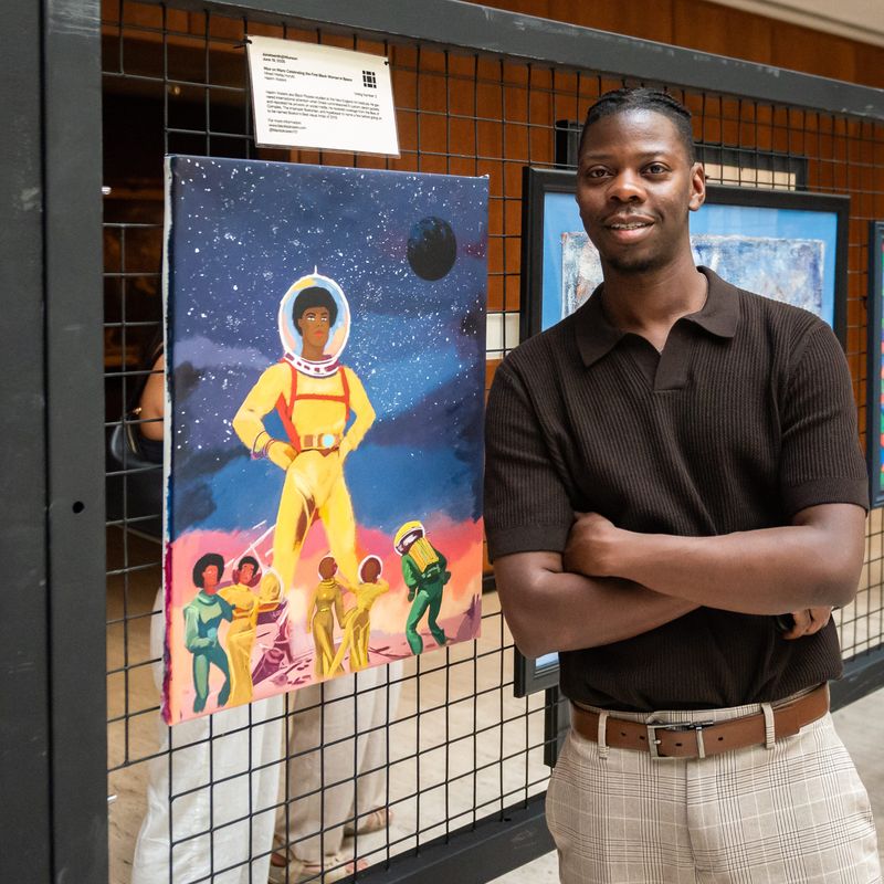 Hakim Waters aka Black Picasso stands with his piece titled "Mae on Mars: Celebrating the First Black Woman in Space" during Juneteenth @ Munson in Utica, NY on Thursday, June 19, 2025. The celebration included live music, poetry, and the Juneteenth Community Exhibition, which showcased works from local African-American artists.