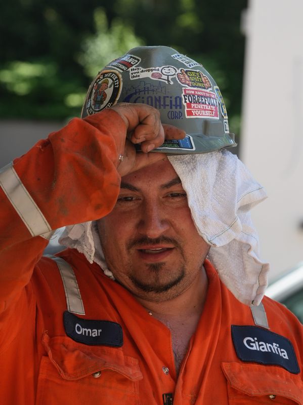 A worker keeps a wet towel over his head and under his helmet as he works in severe heat June 24, 2025. Temperatures in the triple digits are expected to descend once again on the Lower Hudson Valley ahead of the July Fourth holiday.
