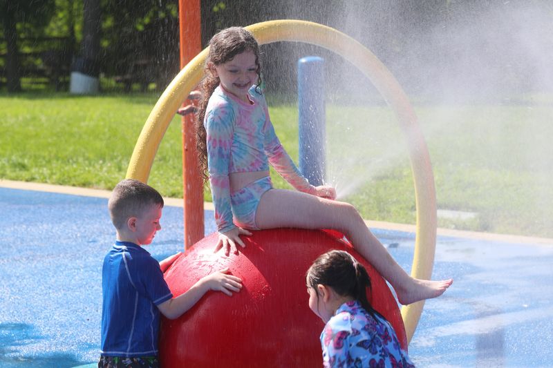 Layla and Sean Miller cool off at Bowdoin Park’s splash pad on June 25, 2025.