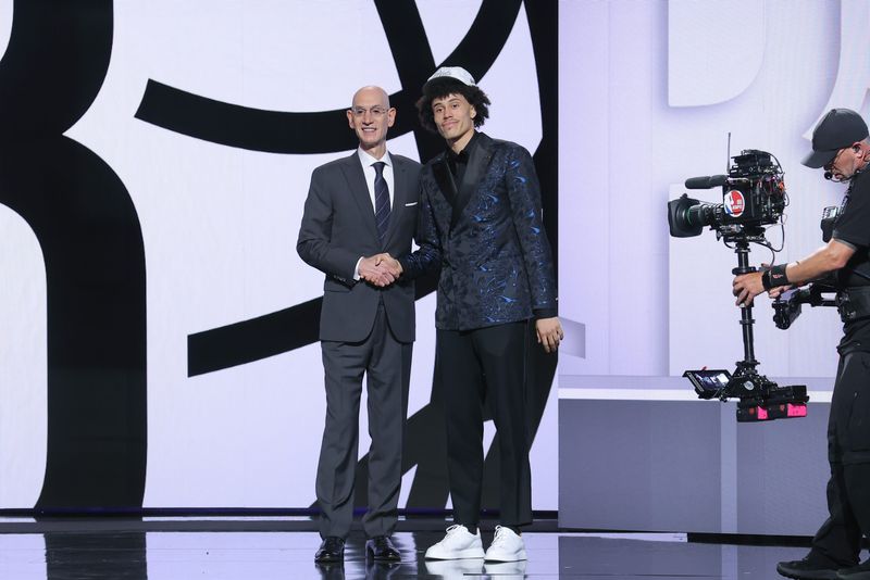 Jun 25, 2025; Brooklyn, NY, USA; Nolan Traore stands with NBA commissioner Adam Silver after being selected as the 19th pick by the Brooklyn Nets in the first round of the 2025 NBA Draft at Barclays Center. Mandatory Credit: Brad Penner-Imagn Images