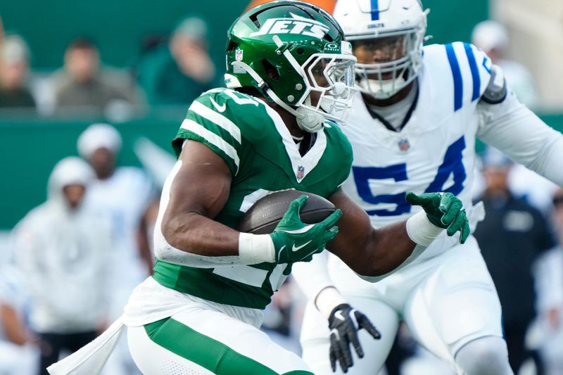 New York Jets running back Breece Hall (20) runs with the ball in the first quarter as Indianapolis Colts defensive end Dayo Odeyingbo (54) is shown in the background, Sunday, November 17, 2024, in East Rutherford.