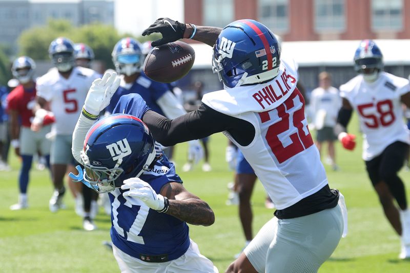 Jul 24, 2025; East Rutherford, NJ, USA; New York Giants cornerback Dru Phillips (22) intercepts a ball intended for wide receiver Wan'Dale Robinson (17) during training camp at Quest Diagnostics Training Center. Mandatory Credit: Vincent Carchietta-Imagn Images
