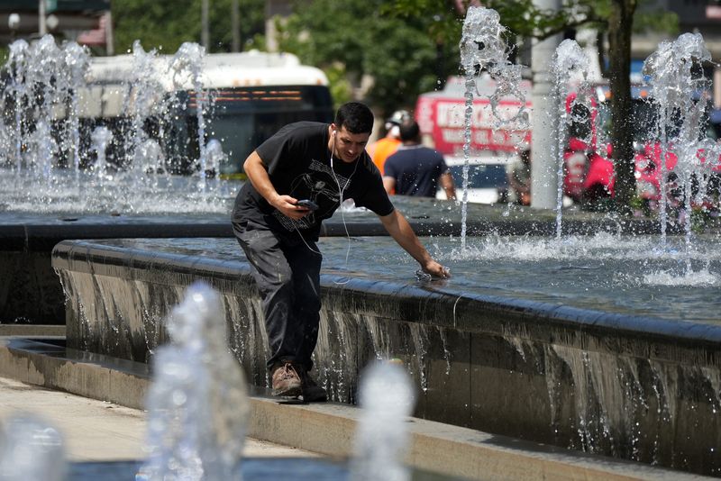Armand Marku of White Plains feels the water from the fountain in downtown White Plains July 29, 2025. A heat advisory is in effect through Wednesday, July 30, with high humidity and temperatures reaching the mid-90s.