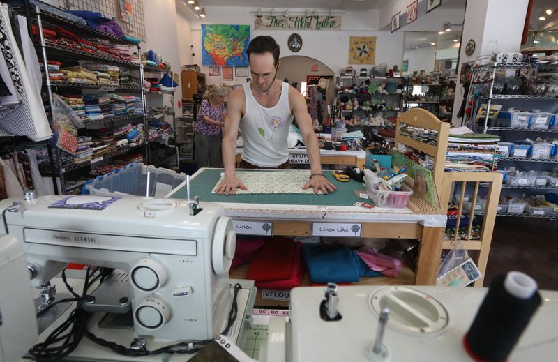 Ansel Eklund, Rochester, measures out fabric for a sewing project at SewGreen Rochester on West Main Street in Rochester on Aug.. 5, 2025.