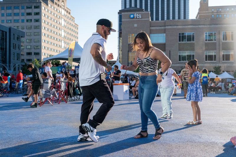 Festival goers dance and enjoy music at the 2025 Rochester Puerto Rican Festival on Parcel 5 in Downtown Rochester