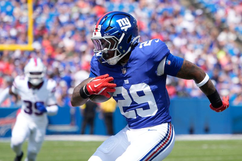 Aug 9, 2025; Orchard Park, New York, USA; New York Giants running back Tyrone Tracy Jr. (29) runs with the ball against the Buffalo Bills during the first half at Highmark Stadium. Mandatory Credit: Gregory Fisher-Imagn Images