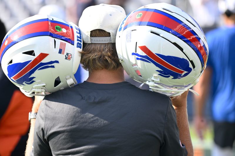 Aug 17, 2025; Chicago, Illinois, USA; A Buffalo Bills team member with helmets is seen during warmups before the pre-season game against the Chicago Bears at Soldier Field. Mandatory Credit: Matt Marton-Imagn Images