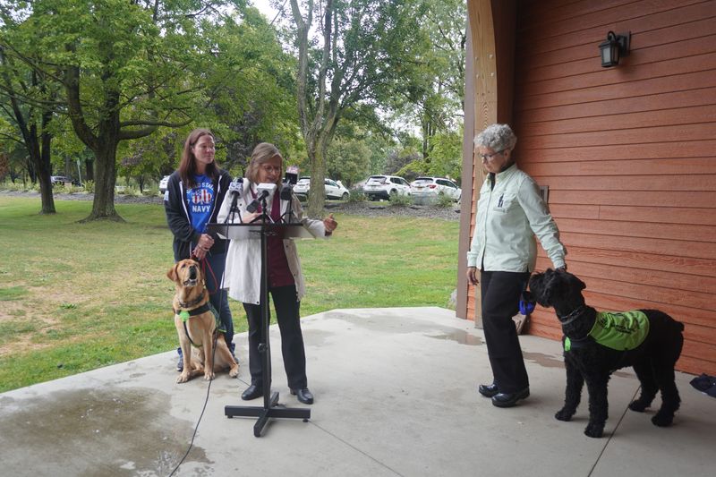 Service Dog Training program graduate Melissa Hughes, Assemblywoman Donna Lupardo and Stand With Me Executive Director Myrph McMahon with dogs Goose and Isla.