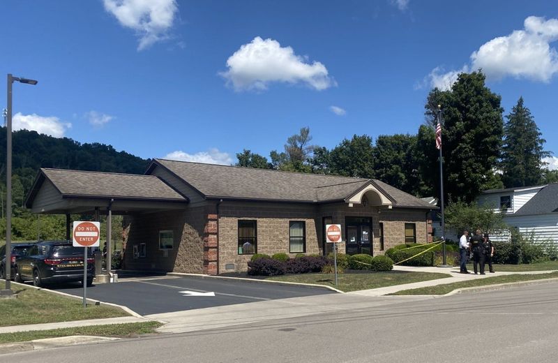 Police confer outside the First Heritage Federal Credit Union in Addison Aug. 22, 2025, following an armed robbery at that location.