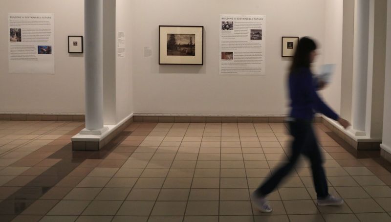 Visitors pass the new photo exhibit Building a Sustainable Future located in the Potter Peristyle at the George Eastman Museum in Rochester Friday, August 29, 2025. The exhibit runs until November 9, 2025.