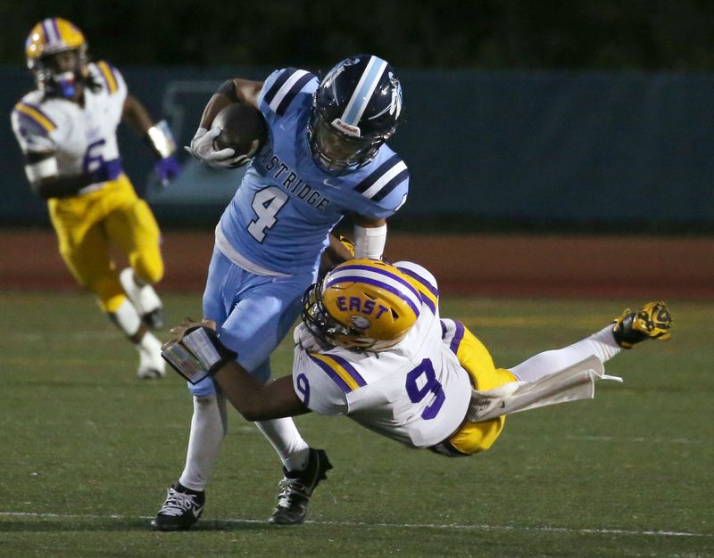 Eastridge defensive back Troy Caulkins is tackled by East/WOIS wide receiver Taye Brown as he runs back an interception in the second quarter during their Section V football season opener at Eastridge High School Friday, Sept. 5, 2025.