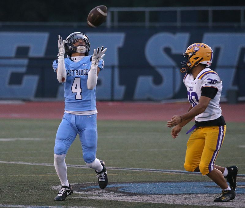 Eastridge’s Troy Caulkins fields a punt and avoids the tackle attempt by East/WOIS’s Chancellor Anivo Williams during their Section V football season opener at Eastridge High School Friday, Sept. 5, 2025.