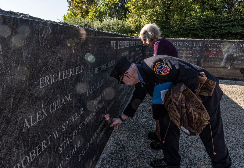 Anne Pettus of Pearl River and her son Keith place flowers at the name of Anne's daughter Laura Longing at the Rockland County Sept. 11 Memorial located at Haverstraw Bay Park Sept. 11, 2025, Both were on hand to attend the Rockland County Sept. 11 memorial service, which marked 24 years since the attack on the World Trade Center.
