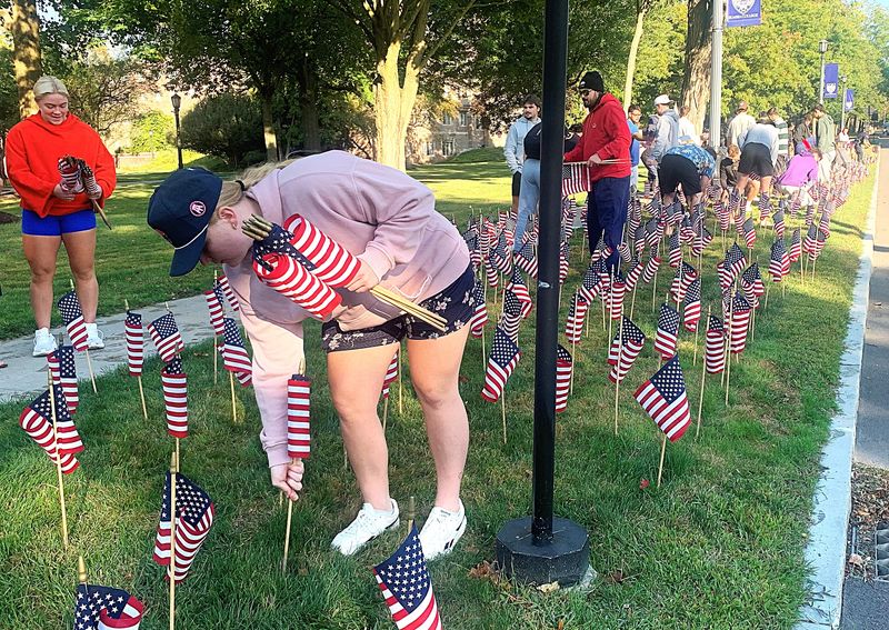 Elmira College students and others place American flags along Park Place on Thursday, Sept. 11, 2025, in remembrance of the almost 3,000 people who died in the Sept. 11, 2001 terrorist attacks.