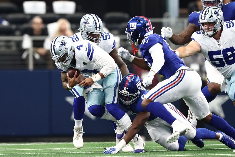 Sep 14, 2025; Arlington, Texas, USA; New York Giants linebacker Brian Burns (0) tackles Dallas Cowboys quarterback Dak Prescott (4) during the second quarter at AT&T Stadium. Mandatory Credit: Kevin Jairaj-Imagn Images