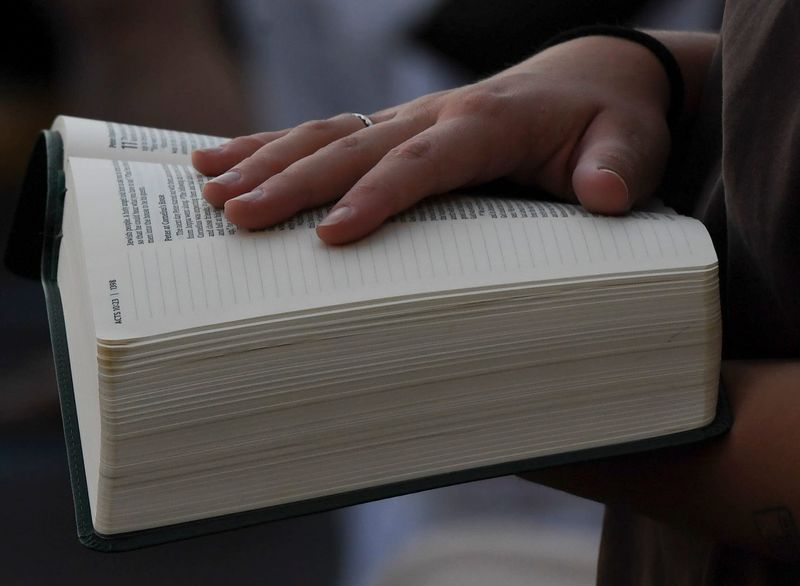 Lena Jackson puts her hand on her Bible Monday, Sept. 15, 2025 during a vigil held in memory of Charlie Kirk at Jeff Lynch Appliances in Greenville, South Carolina.