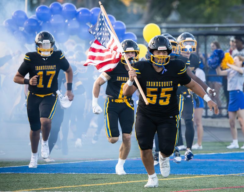 Irondequoit's Owen Smalline carries the American flag during pregame introductions Friday, Sept. 19 at West Irondequoit High School.