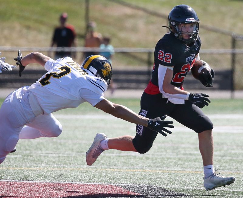 Penfield running back Zane Kropman runs away from the diving tackle attempt by McQuaid’s Thomas Bailey in the first quarter during their Section V football divisional game Saturday, Sept. 20, 2025 at Penfield High School.
