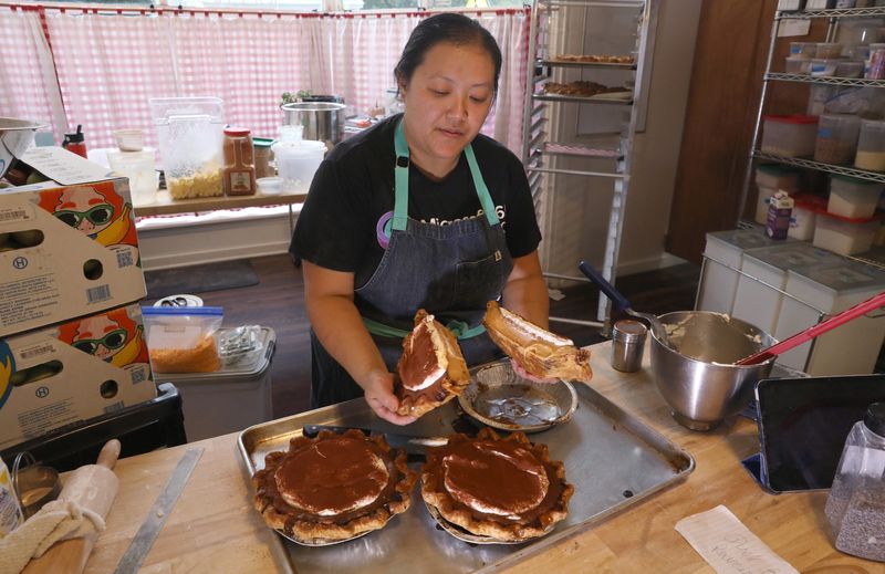 Rebecca Vang shows the creamy insides of the popular Vietnamese Coffee Pie as she slices it up to be sold as individual slices at her newly opened Crust Pie Co. in Rochester Friday, Sept. 26, 2025.