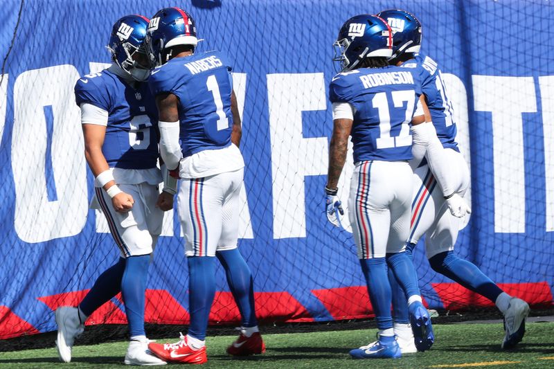 Sep 28, 2025; East Rutherford, New Jersey, USA; New York Giants quarterback Jaxson Dart (6) celebrates with New York Giants wide receiver Malik Nabers (1) after scoring a touchdown during the first quarter against the Los Angeles Chargers at MetLife Stadium. Mandatory Credit: Vincent Carchietta-Imagn Images