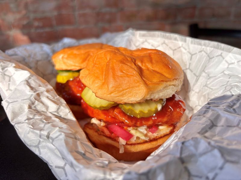 An Aloha chicken sandwich at River Street Sandwich Makers is crispy fried chicken tossed in huli-huli barbecue sauce, topped with fresh jalapeño slices, kewpie house slaw, pickles and red onion, all served on toasted King's Hawaiian hamburger buns