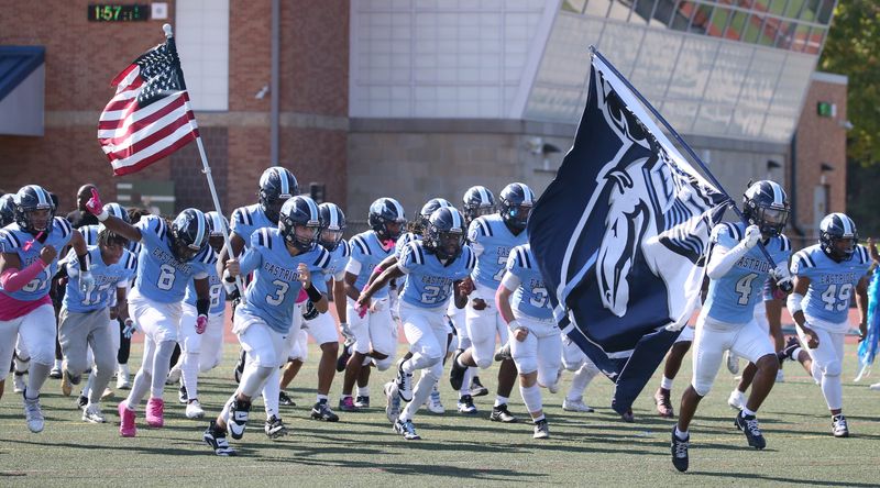 Eastridge players charge onto the field to take on Gates Chili in their Homecoming game during their Section V football matchup Saturday, Oct. 4, 2025 at Eastridge High School.