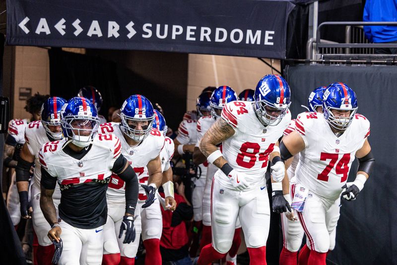 Oct 5, 2025; New Orleans, Louisiana, USA; New York Giants tight end Theo Johnson (84) and guard Greg van Roten (74) run out the tunnel against New Orleans Saints during warmups at Caesars Superdome. Mandatory Credit: Stephen Lew-Imagn Images