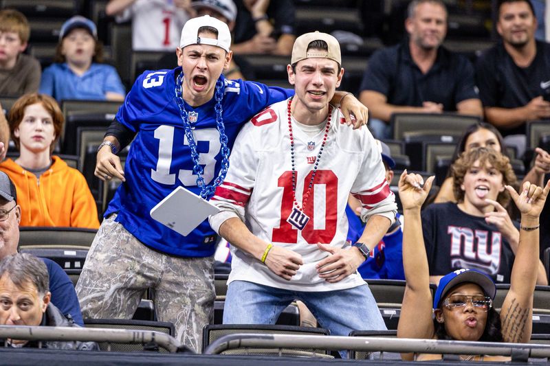 Oct 5, 2025; New Orleans, Louisiana, USA; Fans show emotion as New York Giants run out the tunnel against New Orleans Saints during warmups at Caesars Superdome. Mandatory Credit: Stephen Lew-Imagn Images