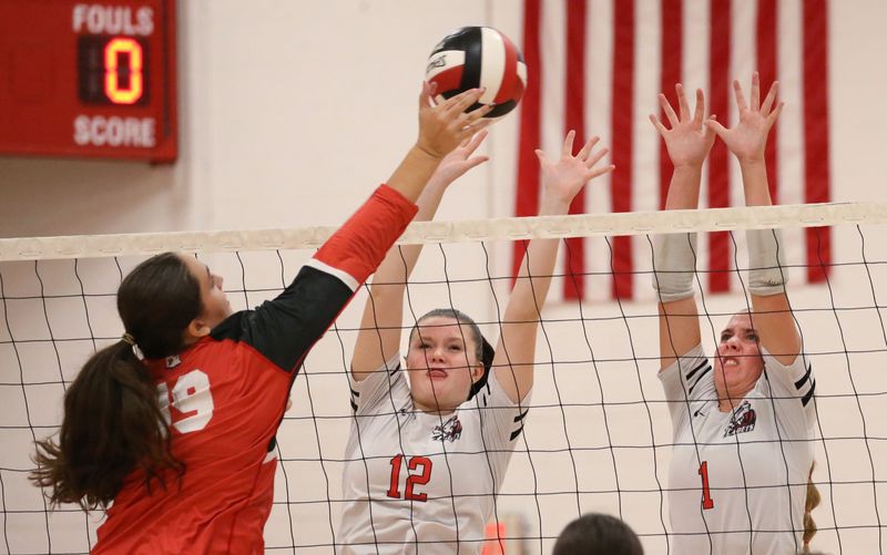 Hilton’s Taylor Green and Maddie Murphy go up together to get the block on a spike from Penfield’s Mackenzie Whitehead during their Section V girls volleyball divisional matchup Tuesday, Oct. 7, 2025 at Penfield High School.