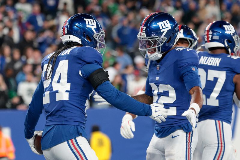 Oct 9, 2025; East Rutherford, New Jersey, USA; New York Giants safety Dane Belton (24) and cornerback Dru Phillips (22) celebrate after a fumble by the Philadelphia Eagles during the fourth quarter of the game at MetLife Stadium. Mandatory Credit: Vincent Carchietta-Imagn Images
