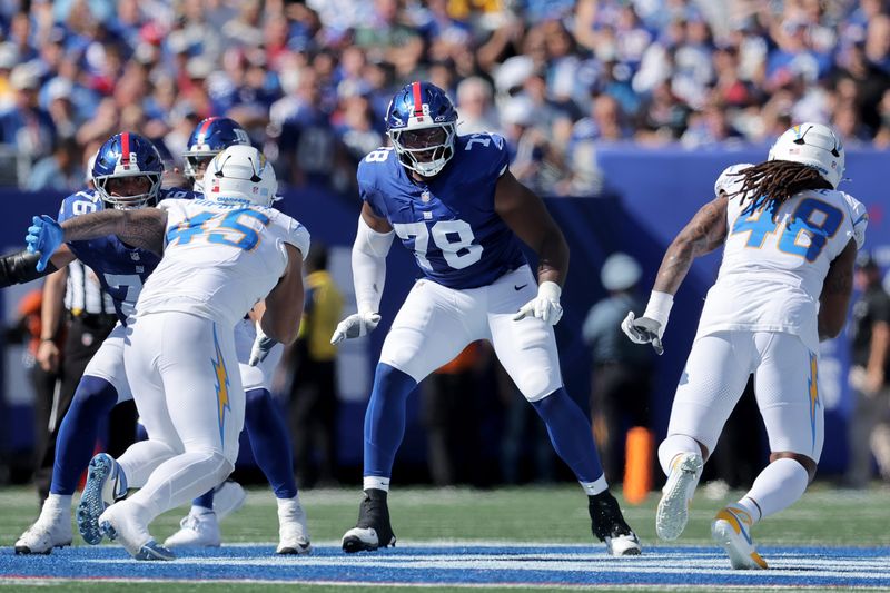 Sep 28, 2025; East Rutherford, New Jersey, USA; New York Giants offensive tackle Andrew Thomas (78) blocks against Los Angeles Chargers linebackers Tuli Tuipulotu (45) and Bud Dupree (48) during the second quarter at MetLife Stadium. Mandatory Credit: Brad Penner-Imagn Images