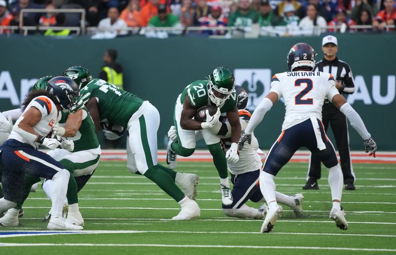 Oct 12, 2025; Tottenham, United Kingdom; New York Jets running back Breece Hall (20) runs the ball against the Denver Broncos during an NFL International Series game at Tottenham Hotspur Stadium. Mandatory Credit: Kirby Lee-Imagn Images