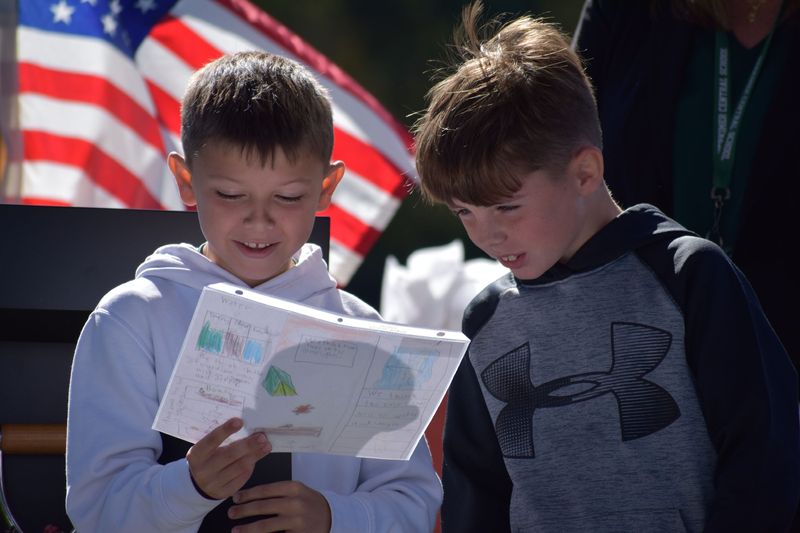 Herkimer Elementary School fourth graders Miles Rhymestine, left, and Aiden Olejarczyk look at the Erie Canal brochure they made that shows robots operating the canal in 200 years. The pair won the Erie Canal 200 Years from Now Contest for their school and received their award during a ceremony at the Herkimer Marina Festival, which celebrated the canal's bicentennial, on Friday, Oct. 10, 2025.
