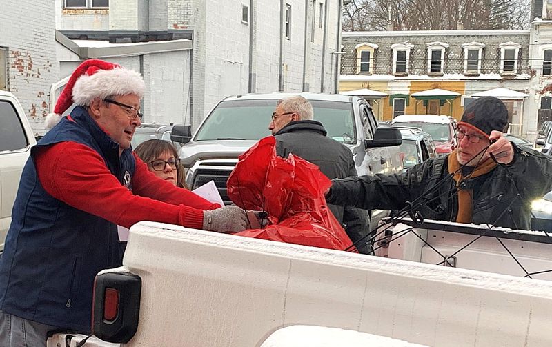 Arctic League director Mike Wayne, left, helps a delivery volunteer load Christmas gift bags into his pickup truck on Tuesday, Dec. 24, 2024.