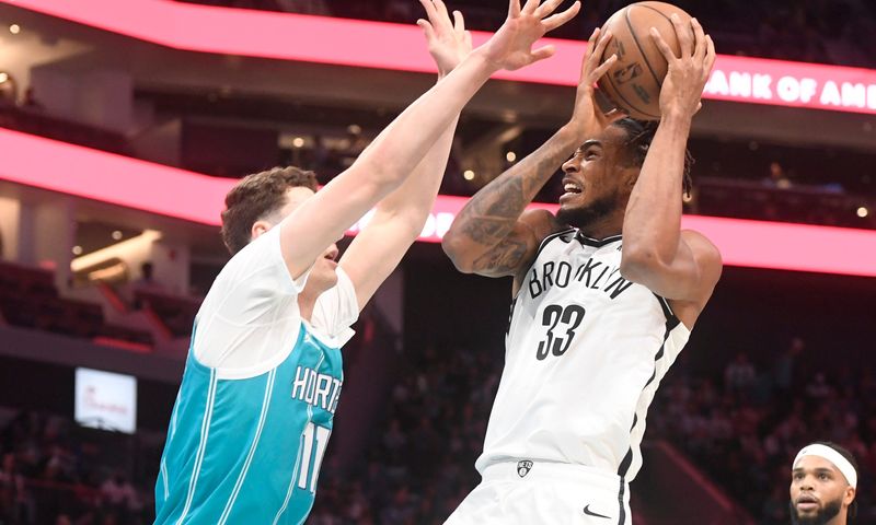 Oct 22, 2025; Charlotte, North Carolina, USA; Brooklyn Nets center Nic Claxton (33) looks to pass as he is defended by Charlotte Hornets centenaries Ryan Kalkbrenner (11) during the first half at the Spectrum Center. Mandatory Credit: Sam Sharpe-Imagn Images