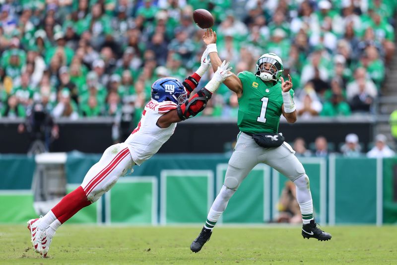Oct 26, 2025; Philadelphia, Pennsylvania, USA; Philadelphia Eagles quarterback Jalen Hurts (1) passes against New York Giants linebacker Kayvon Thibodeaux (5) in the third quarter at Lincoln Financial Field. Mandatory Credit: Bill Streicher-Imagn Images
