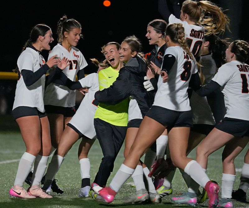 Churchville-Chili players mob goalkeeper Tessa Wood as they celebrate their shoot-out win over Spencerport during their Section V Class AA girls soccer championship finals Sat. Nov. 1, 2025 at Webster Schroeder High School. The championship ended in a 1-1 draw, with both teams named co-champions. In the penalty kicks shootout, Churchville-Chili prevailed and will advance in the playoffs.